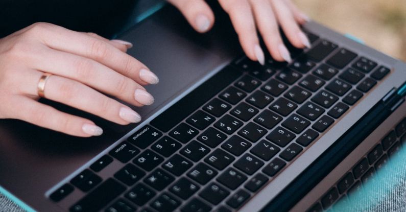 Tech Start-Ups - A person sitting on a bench with their hands on a laptop