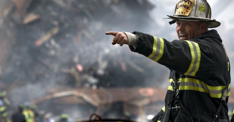Natural Disasters - Fire Fighter Wearing Black and Yellow Uniform Pointing for Something