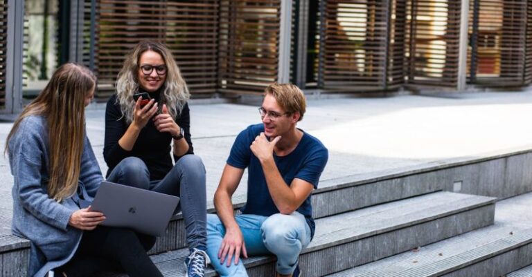 Millennials - Three Persons Sitting on the Stairs Talking With Each Other