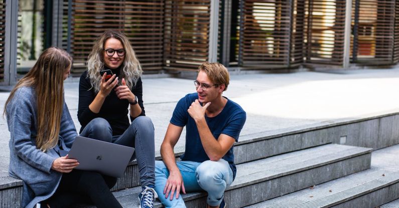 Millennials - Three Persons Sitting on the Stairs Talking With Each Other
