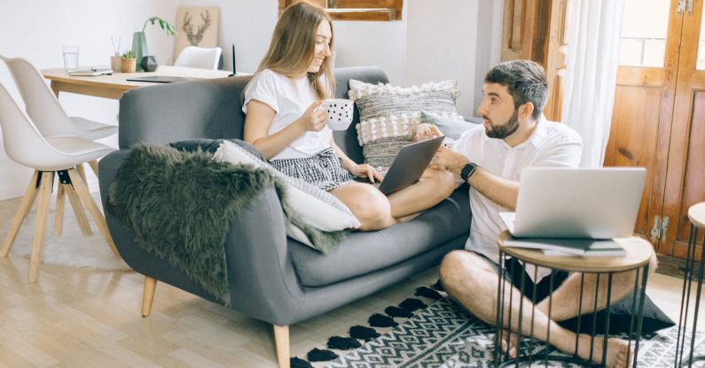 Digital Nomads - Man and Woman Talking while Working at the Living Room