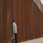Refugee Crisis - Man Standing on Fence