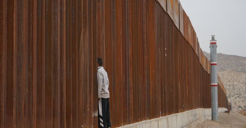 Refugee Crisis - Man Standing on Fence